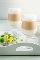 Two latte coffee with spring flowers on white table