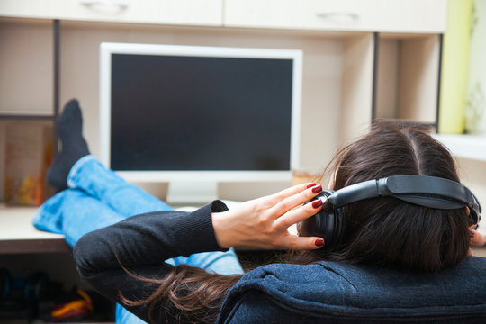 Young woman in earphones listen to music at home