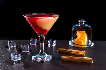 cocktail in glass on a long stalk on the bar black granite