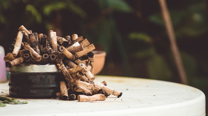 Overfull. Ashtray full of cigarettes, like the smoker's lungs.