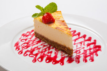 Cheesecake with fresh strawberries on white plate
