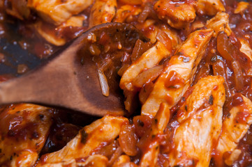 Chicken in tomato sauce cooking in a pan
