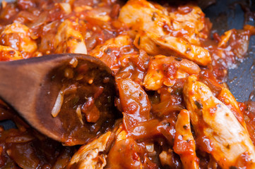 Chicken in tomato sauce cooking in a pan