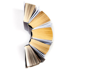 Top view of colorful hardback books in a circle. Open book, fanned pages. Back to school copy space. Education background.