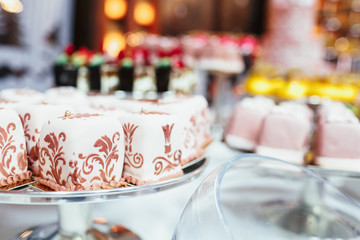 Square cakes covered with pastel pink cream