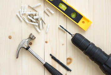 Drill and hammer, levels and screw on wooden background for DIY concepts