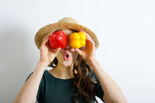Young woman playing with colorful peppers
