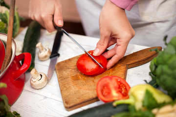 Woman cutting tomato on chopping board