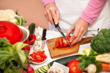Woman slicing tomato on chopping board