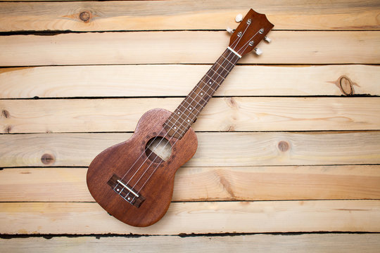 Hawaiian four-stringed ukulele guitar on wooden background