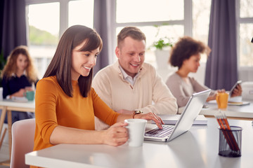 Young happy people discussing business issues in modern light office 