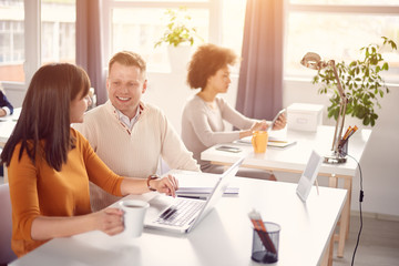 Young happy people discussing business issues in modern light office 