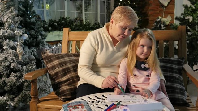 Grandma Drawing With Little Girl Telling Story Playing Together New Year Interior Lights Cosy Room Soft Light Traditional Attributes of Christmas Eve