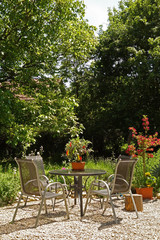 Sitzgruppe mit Tisch in einem blühenden Garten
