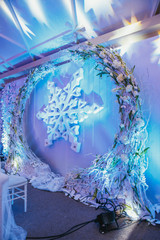 Wreath of white branches around large snowflake on the wall