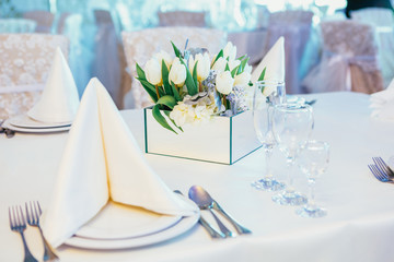 Box with tulips stands on dinner table