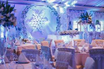 Round dinner tables stand before the wall with large snowflake