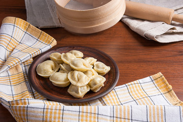 Boiled Ukrainian meat dumplings or ravioli on wooden background.