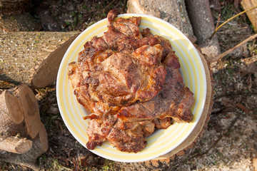 Juicy pork steaks cooked on an open flame grill on big white plate..