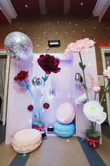 Cosy corner decorated with large paper flowers and pillows in form of macaroons