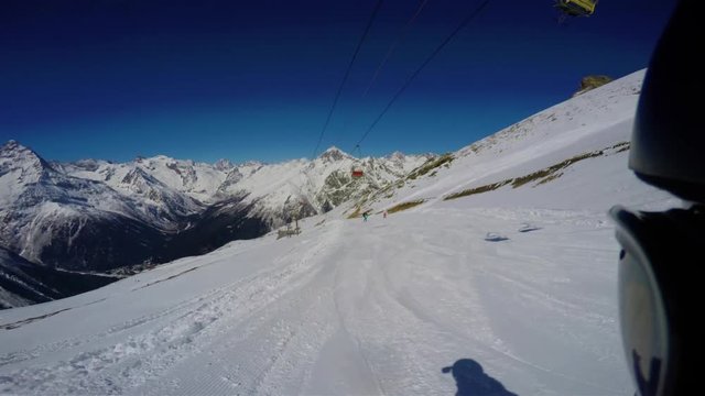 Snowboarder hits the slope in ski resort. FPV