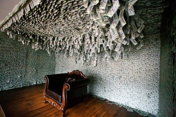 Large leather chair stands in the room covered with dollars