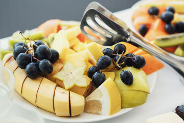 Black grape and sliced apples and bananas