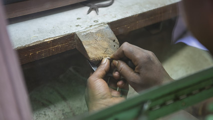 Indian Jeweler making an Oriental Jewelry in workshop. Handmade traditional jewel Manufacturing in Jaipur