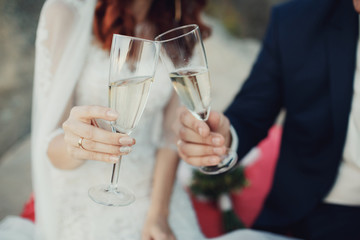 Champagne glasses in hands of bride and groom