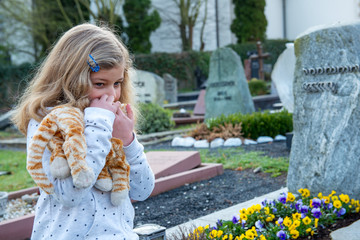 sad girl in front of grave