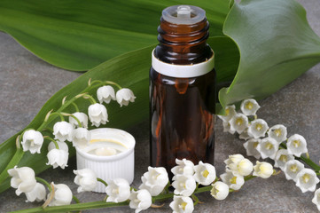 Flacon d'huile essentielle de muguet et brins de muguet