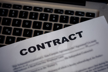 Naklejka premium Contract document and lap top