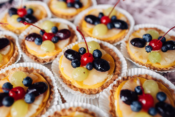 The baked baskets with fruits standing on the buffet table