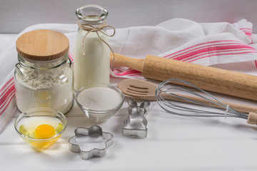 Preparation of gingerbread man cookies. Ingredients, cookie cutters  and kitchen tools on parchment paper