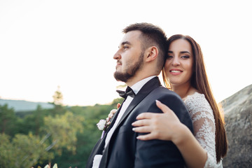 The lovely couple in love  embracing and sitting    on the stones