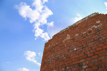 Red brick wall on blue sky background