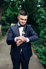 The handsome groom looking at watch