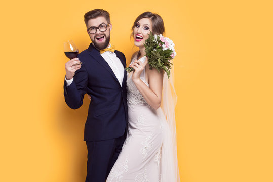 Smiling young newly married on a yellow background