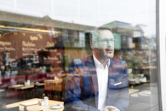 Confident mature businessman looking out of window