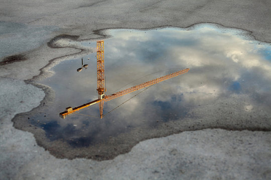Crane tower reflection in the puddle