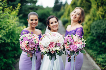 The bride with bridesmaids keeping bouquets