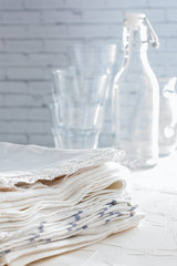 A stack of white cotton kitchen towels on the table, selective focus