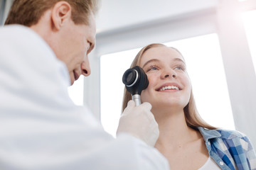 Elderly specialist exploring patient skin at work