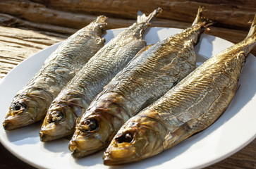 Geräucherter Fisch / Bücklinge auf Teller mit Holz / Treibholz Hintergrund
