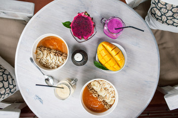 Healthy Raw Fruit Breakfast on White Rustic Table. Color Smoothie with Mango and Pitaya Fruits.
