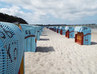 Preseason at the Baltic Sea -
Blue beach baskets on the beach under a slightly cloudy sky.

