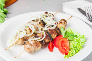 Skewers of grilled meat and vegetables on the white plate, restaurant menu, Selective focus, Close up