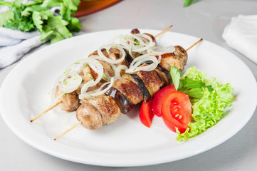 Skewers of grilled meat and vegetables on the white plate, restaurant menu, Selective focus, Close up