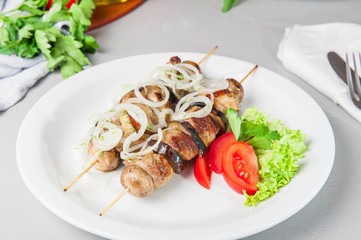 Skewers of grilled meat and vegetables on the white plate, restaurant menu, Selective focus, Close up
