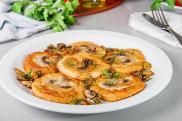 Potato pancakes with mushrooms on the white plate on the table with different bright ingredients, restaurant menu, Selective focus
